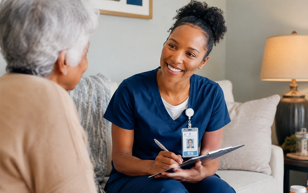 Home healthcare nurse with a clipboard speaking with a patient in a cozy living room environment